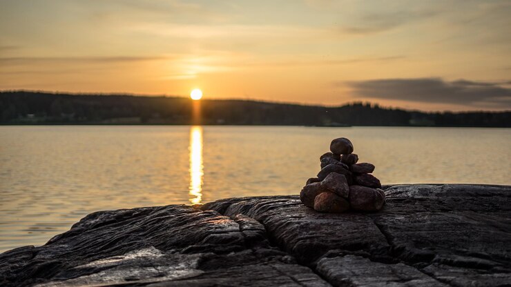 Photo vue panoramique du lac avec un tas de pierres contre le ciel au coucher du soleil