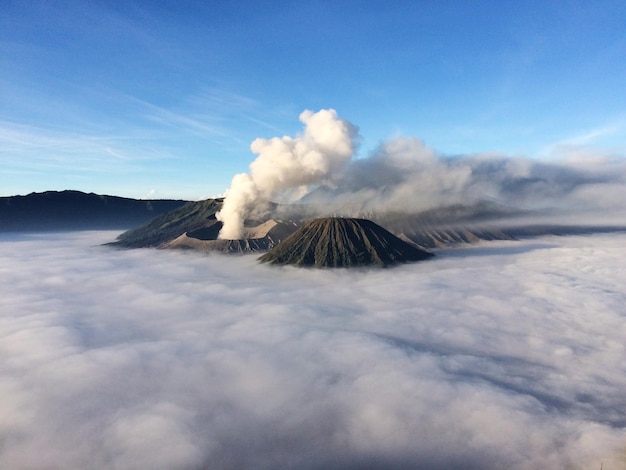 Photo vue panoramique du mont bromo au milieu des nuages contre le ciel bleu