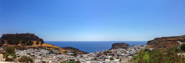 Photo vue panoramique du port coloré du village de lindos et de l'acropole de rhodes vue aérienne du magnifique paysage, des ruines anciennes, de la mer avec des voiliers et du littoral de l'île de rhodes dans la mer égée