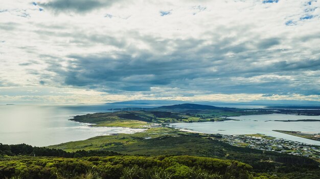 Photo vue panoramique d'une forêt verte contre la mer à invercargill en nouvelle-zélande par temps nuageux
