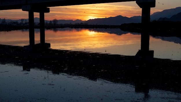 Vue panoramique de l'heure d'or du coucher du soleil sous la silhouette du pont