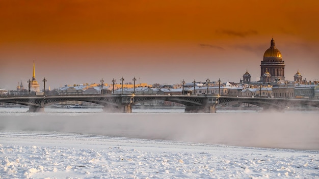 Vue panoramique d'hiver de saint-pétersbourg au coucher du soleil cathédrale isaac et pont blagoveshenskiy sur fond...