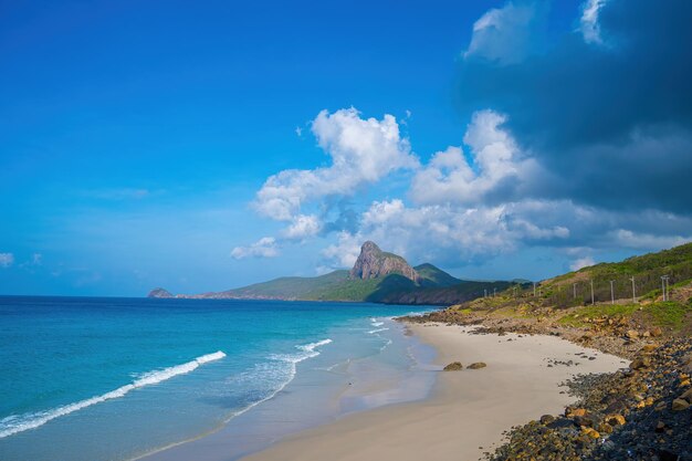 Vue panoramique de l'île côtière de Con Dao d'en haut avec des vagues littoral ciel clair et route bleue mer et montagne Vue aérienne de la plage de Bai Nhat avec jour nuageux Concept de voyage