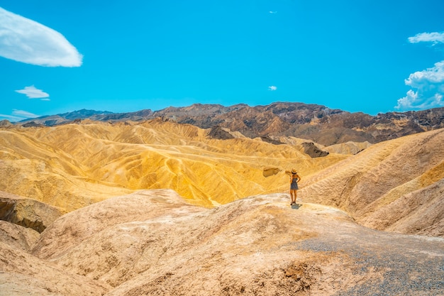 Vue Panoramique D'une Jeune Femme En Robe Appréciant La Vue Sur Le Point De Vue De Zabriskie Point, En Californie. états Unis