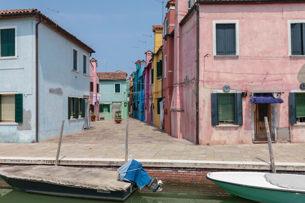 Vue panoramique sur les maisons aux couleurs vives et le canal d'eau avec des bateaux à Burano, c'est une île de la lagune de Venise. Journée ensoleillée d'été et ciel bleu
