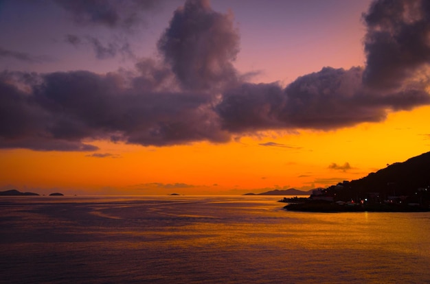 Vue panoramique de la mer contre un ciel orange nuageux au coucher du soleil