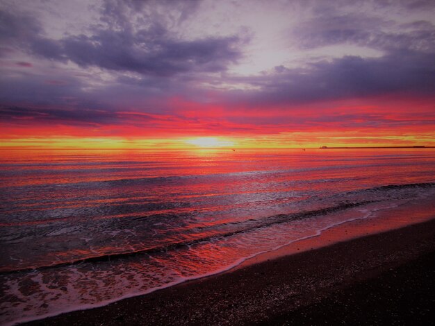 Vue panoramique de la mer contre un ciel spectaculaire au coucher du soleil