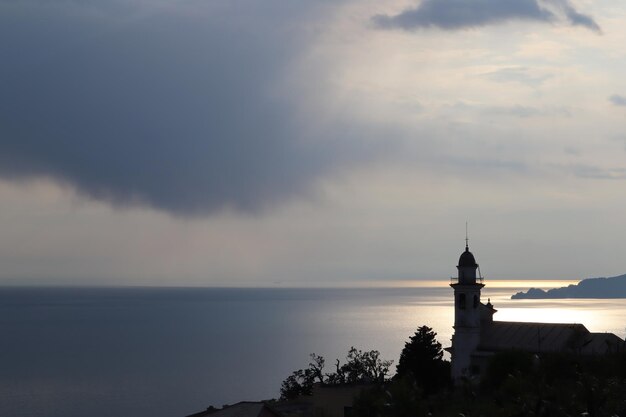 Vue panoramique de la mer par le bâtiment contre le ciel au coucher du soleil