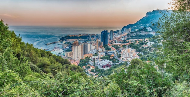 Vue panoramique de Monaco au coucher du soleil depuis la route de la Grande Corniche, monument emblématique de la Côte d'Azur, Côte d'Azur