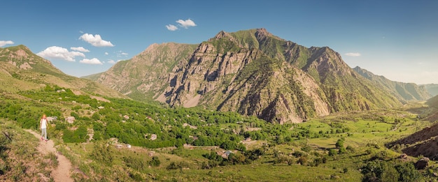 Vue panoramique sur les montagnes dans la réserve naturelle de Yeghegis Une randonneuse marche le long du chemin jusqu'à la forteresse de Smbataberd en Arménie