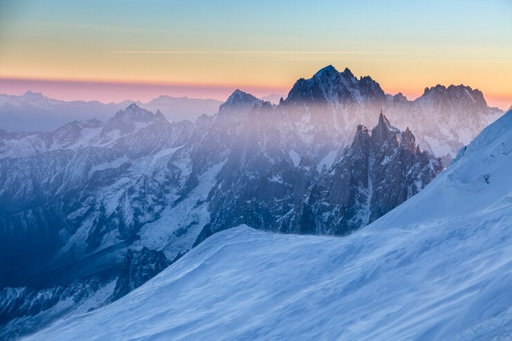 Photo vue panoramique sur les pitons rocheux de l'aiguille du midi au lever du soleil. chamonix, france. image panoramique du concept de randonnée. moment parfait dans les hauts plateaux alpins.