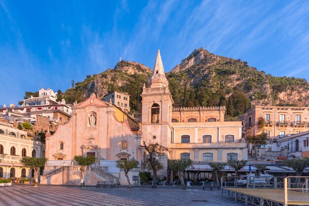 Vue panoramique sur la place du matin Piazza IX Aprile avec l'église San Giuseppe, la tour de l'horloge et le volcan Etna en arrière-plan, Taormina, Sicile, Italie