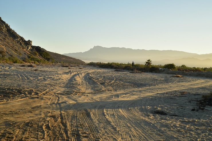 Photo vue panoramique de la plage de sable et des montagnes contre un ciel dégagé