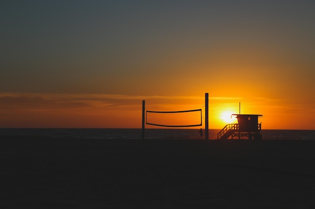 Vue panoramique de la plage en silhouette contre le ciel au coucher du soleil