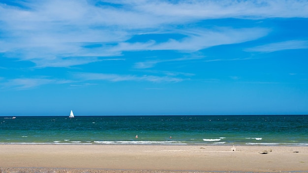 Vue panoramique de la plage avec yacht à voile en mer et ciel en arrière-plan