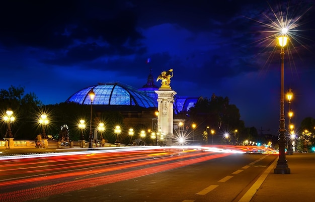 Vue panoramique sur le pont Alexandre III illuminé au crépuscule.