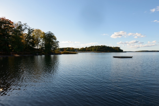 Vue panoramique de la rivière calme et ciel bleu clair avec forêt d'automne le long de la rivière à Naantali en Finlande