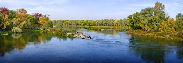 Vue panoramique sur la rivière. Forêt d'automne sur la rive. Un ciel clair et sans nuages.