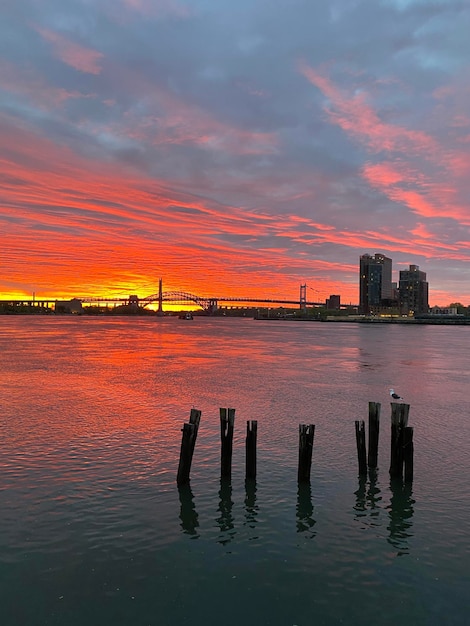 Photo vue panoramique de la rivière par les bâtiments contre le ciel au coucher du soleil