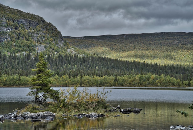 Vue panoramique de la rivière par les montagnes contre un ciel nuageux