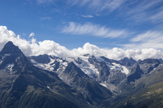 Vue panoramique sur la scène dramatique du ciel bleu et des montagnes dans le parc national Dombay, Caucase, Russie. Paysage d'été et journée ensoleillée