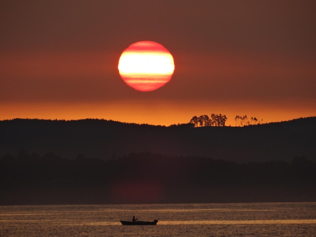 Photo vue panoramique de la silhouette du bateau au coucher du soleil