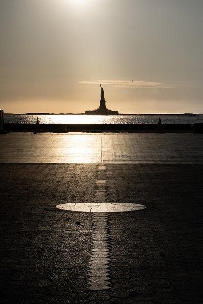 Photo vue panoramique de la silhouette de la statue de la liberté contre le ciel au coucher du soleil depuis le parc de la batterie