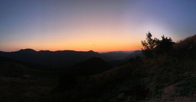 Photo vue panoramique des silhouettes de montagnes sur un ciel orange