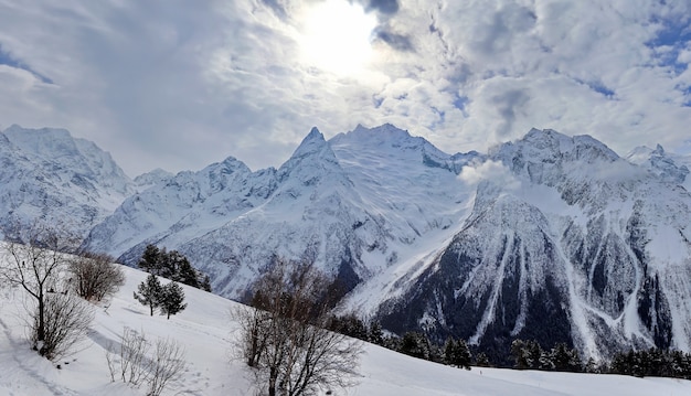 Vue panoramique sur les sommets des montagnes enneigées dans le ciel bleu des nuages du Caucase