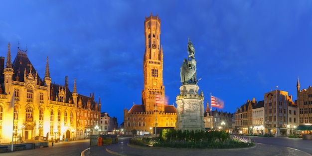 Vue panoramique sur la tour Belfort et la statue de Jan Breydel et Pieter de Coninck sur la Grote Markt ou la place du marché pendant l'heure bleue du soir, Bruges, Belgique