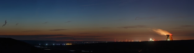 Vue panoramique sur la vallée de la rivière avec une centrale nucléaire. Paysage après le coucher du soleil, le ciel crépusculaire.