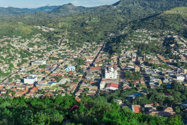 Vue panoramique d'une ville avec une cathédrale entourée de montagnes par une journée ensoleillée