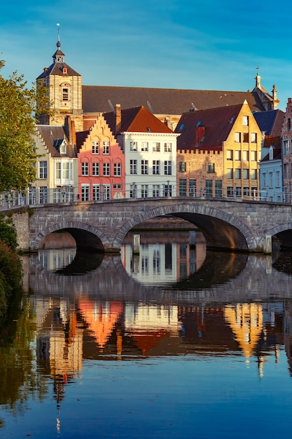 Vue panoramique sur la ville du canal de Bruges avec de belles maisons colorées médiévales, un pont et des reflets dans l'heure d'or du soir, Belgique