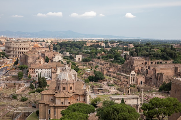 Vue panoramique de la ville de Rome avec forum romain et Colisée du monument Vittorio Emanuele II également connu sous le nom de Vittoriano. Journée ensoleillée d'été et ciel bleu dramatique