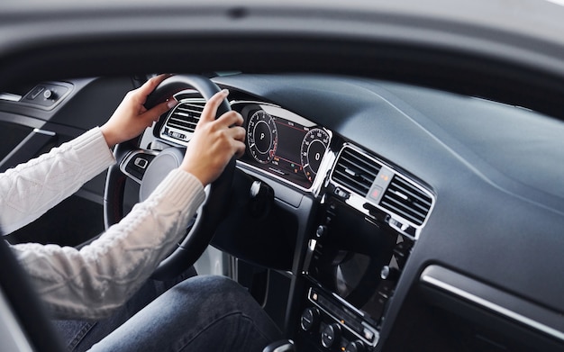 Vue particulaire de l'homme en tenue de soirée qui monte une toute nouvelle voiture.