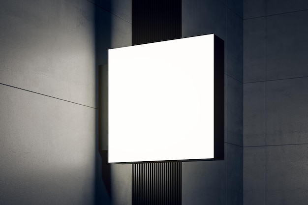 Vue en perspective sur une signalisation carrée blanche et éclairée sur un mur sombre d'un bâtiment moderne avec un espace de copie pour votre logo ou le nom de votre entreprise, maquette de rendu 3D