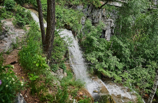 vue sur une petite cascade de rivière de montagne parmi de grands pavés depuis une falaise