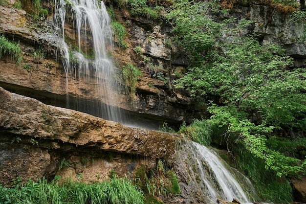 Vue d'une petite cascade de rivière de montagne parmi de grands pavés d'une falaise