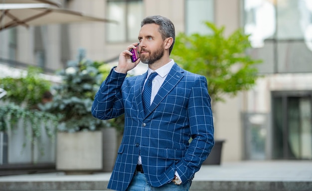 Vue photo de l'homme d'affaires appel au téléphone et parler l'homme d'affaires a un appel téléphonique en plein air