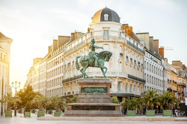 Photo vue sur la place martroi avec statue de sainte jeanne d'arc à orléans ville pendant le coucher du soleil en france