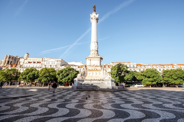 Vue sur la place Rossio avec colonne monument pendant le lever du soleil dans la ville de Lisbonne, Portugal