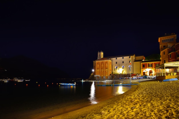 Vue de la plage de Baia del Silenzio la nuit avec des lumières et des reflets spectaculaires