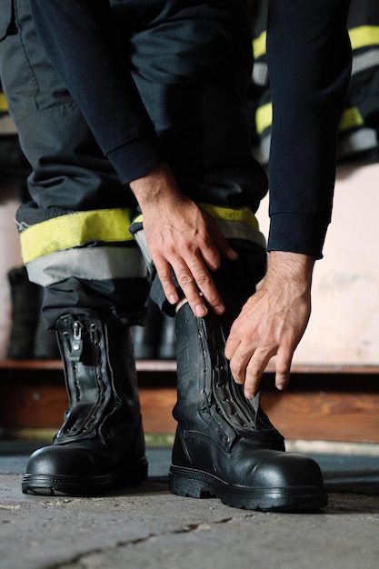 Vue d'un pompier attachant les lacets de ses bottes