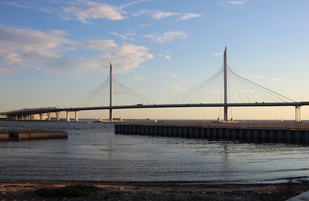 vue sur le pont du câble et la baie au coucher du soleil reflet des pylônes et des piliers du pont dans l'eau