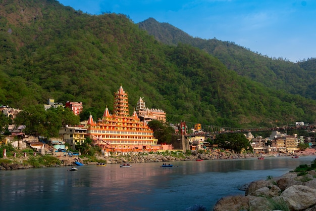 Photo vue sur le pont du fleuve ganga lakshman jhula et le temple tera manzil trimbakeshwar à rishi