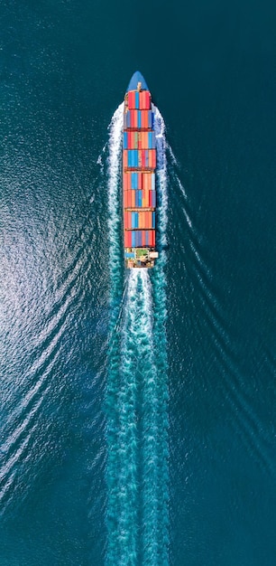 Vue de portrait aérien d'un cargo intelligent avec traînée dans l'océan mer navire transportant un conteneur depuis un dépôt de conteneurs personnalisé aller au concept océanique expédition de fret par service de navire