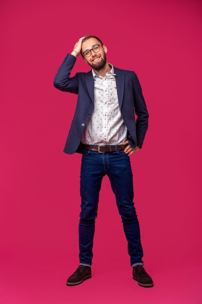 Vue portrait d'un homme d'affaires heureux attrayant avec des lunettes sur fond rose