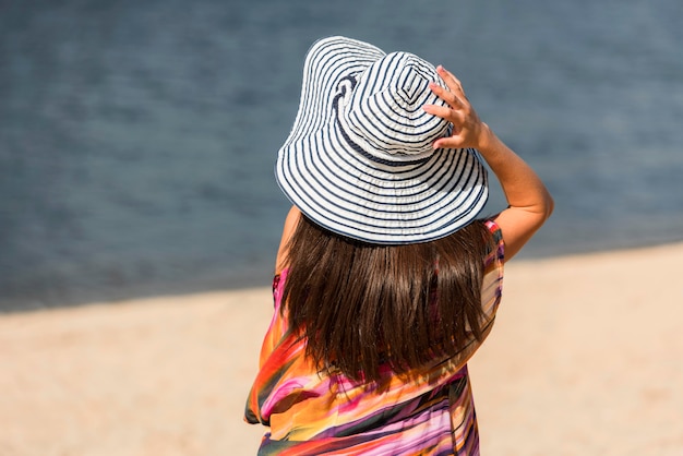 Photo vue postérieure, de, femme, à, chapeau, plage