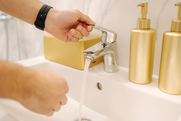 Vue à la première personne de l'homme se lavant les mains à la maison gros plan des mains humaines garder le concept propre