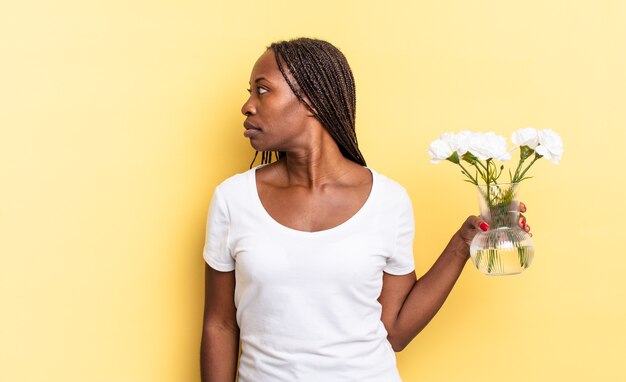 en vue de profil, cherchant à copier l'espace devant, en pensant, en imaginant ou en rêvant. concept de fleurs décoratives